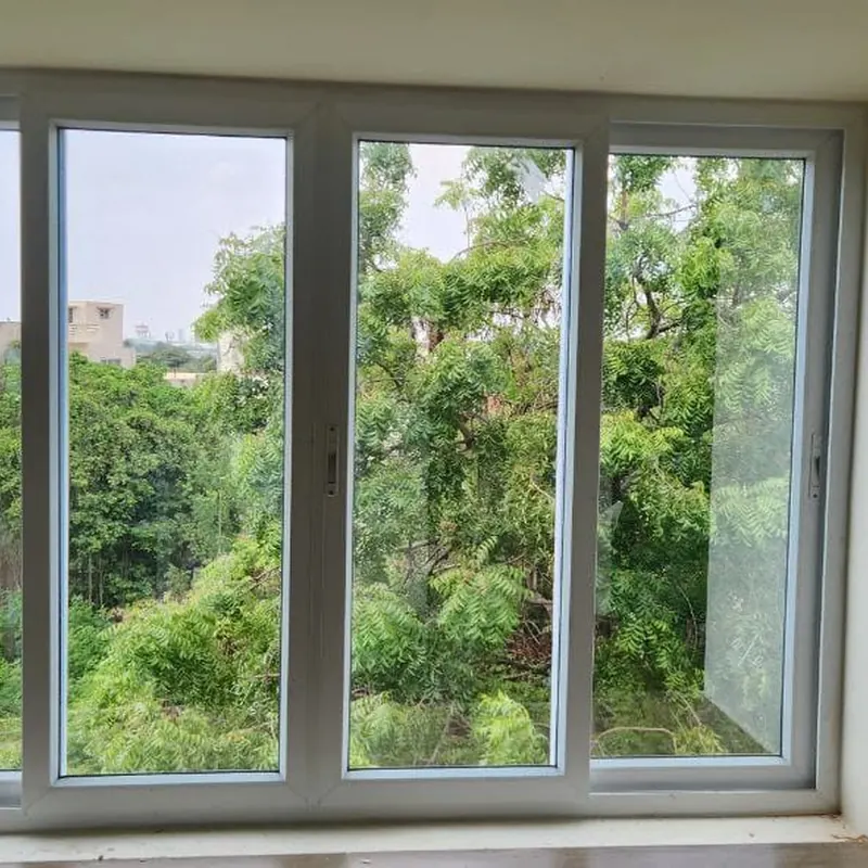 Four-panel white sliding window with a tree view
